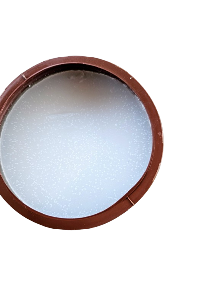 An opened container of Americas coconut Sun Tan tanning cream with a brown lid, featuring product information on the label.