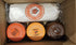 Three containers and a wrapped item in a cardboard box with visible branding.