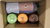 Three jars with labels and a mesh bag inside a cardboard box.