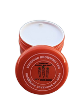 A container of Americas Carrot Sun Tan tanning cream with a red lid, featuring product information on the label.
